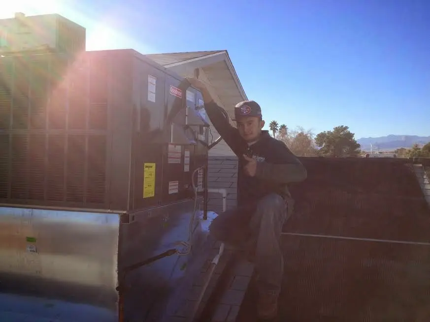 HVAC technician performing Boiler Repair on a rooftop unit in Easley
